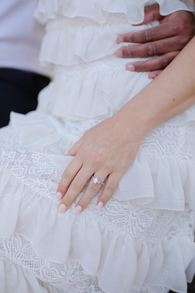 Close up of the woman's hand, showing her engagement ring.