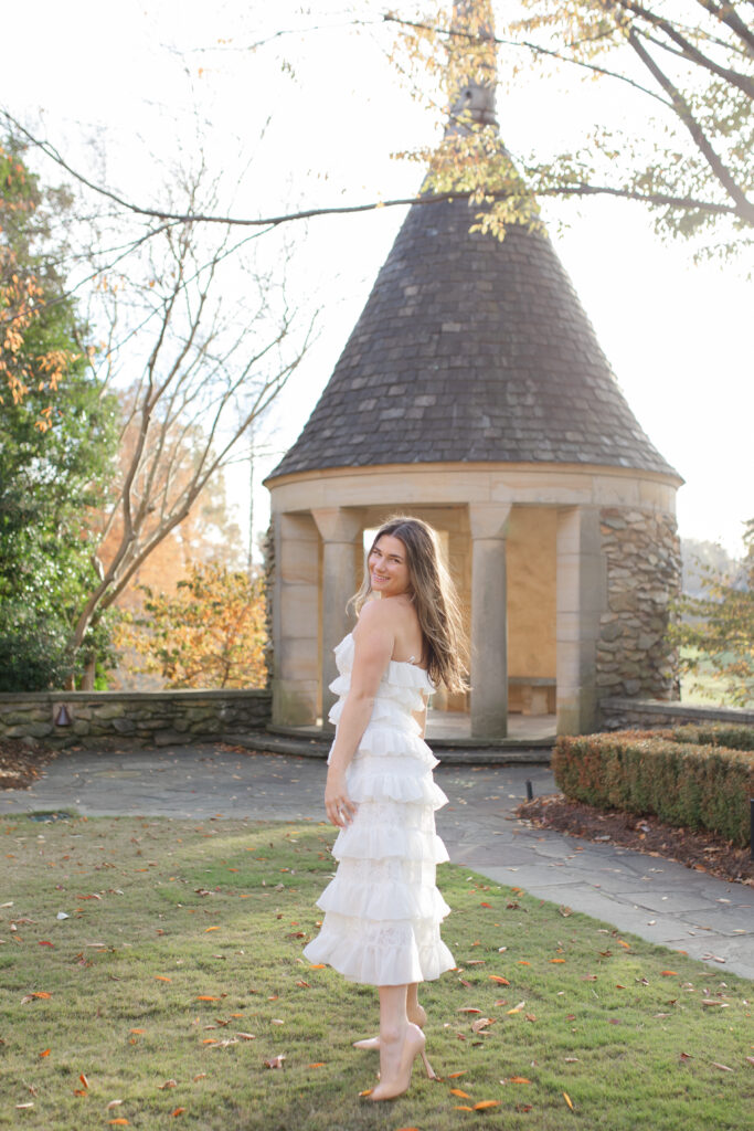 The woman stands alone, smiling at the camera in front of the rotunda at Graylyn Estate.