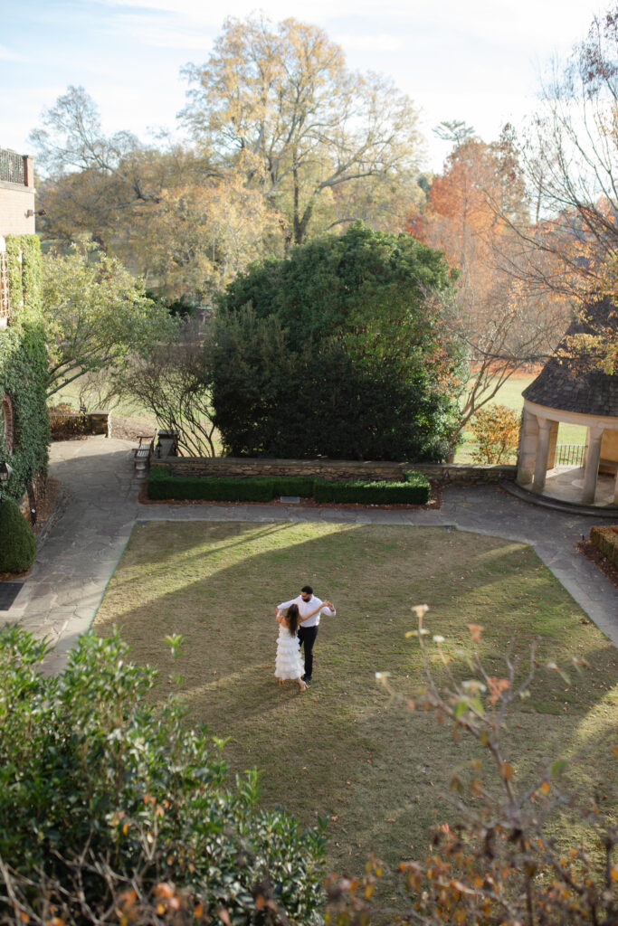 Man and woman dance together in the courtyard garden of Graylyn Estate.