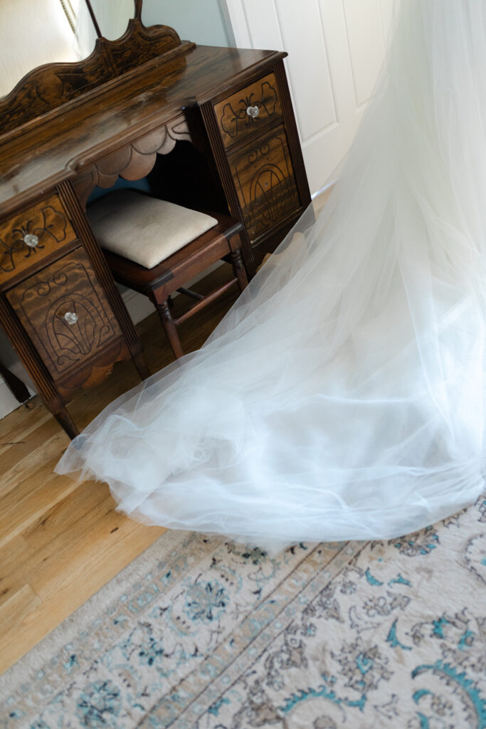 The bride's dress drags across the floor of her bridal suite as she walks out.