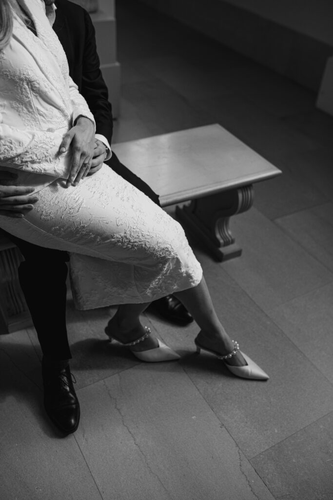 A close up detail shot of the man and woman's feet as they sit together on the bench.